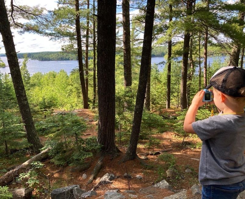 Owen taking a picture in the woods