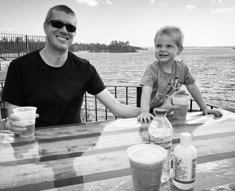 Owen and Ben at a table with a lake in the background