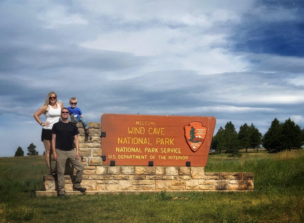 Family at Wind Cave Entrance Sign